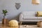 Boho living room with grey sofa, large poster and natural accessories. Cosy home decor.