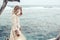 Boho model wearing dress and straw hat on the beach