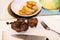 Boiled beef shin on kitchen board, knife, fork, sliced dumplings on plate,lid.