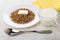 Boiled buckwheat with butter, cup of milk, yellow napkin, spoon