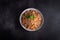 Boiled buckwheat cereal with carrot, parsley and butter in a bowl on a dark background. Traditional Russian dish on dark