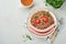 Boiled buckwheat porridge, meat sausages, tomato and microgreens of peas in a white plate in stone grey background. Fun food art