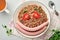 Boiled buckwheat porridge, meat sausages, tomato and microgreens of peas in a white plate in stone grey background. Fun food art