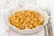 Boiled chick-pea in white bowl on wooden background