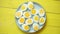 Boiled chicken eggs on a blue ceramic plate. The concept of Easter Holidays