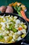 Boiled cod with potatoes, celery and carrots. Close-up of pan ready to cook, on green wooden background