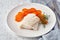 Boiled codfish with carrot and dill on white plate, fodmap dash paleo diet, side view closeup, napkin and cutltery on background