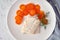 Boiled codfish with carrot and dill on white plate, fodmap dash paleo diet, top view closeup, napkin and  cutltery on background