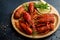 Boiled cooked crayfish crawfish ready to eat on wooden plate on
