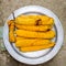 Boiled corn on an aluminum tray. Yellow boiled young corn, useful and food