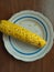 Boiled corn on plate. Cereal, fruits. Cooked maize.
