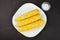 Boiled corn with white and yellow grains on a white square plate,