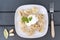 Boiled dumplings with sour cream on a plate, top view, fork