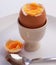 Boiled egg,cut open in eggcup,on plate with spoon