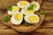 Boiled eggs with parsley on cutting board on wooden table