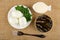 Boiled eggs and parsley in saucer, bowl with mayonnaise, opened jar with sprats, fork on mat. Top view