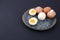 Boiled eggs on a plate. Black background. Place for text. Protein and nutrition