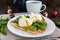 Boiled eggs in a pouch (poached) on toast and crisp green leaves of arugula and a cup of tea