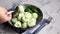 Boiled khinkali made of dough with spinach. Garnished with Red Chilli, Dill and Parsley. On a light gray background under