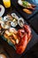 Boiled lobster, fresh oysters, shrimps, mussels and clams served in black stone plate