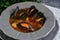 Boiled mussels soup on a grey plate