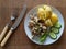 Boiled potato, mushrooms, cucumber and lettuce leaf served on white plate