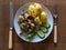 Boiled potato, mushrooms, cucumber and lettuce leaf served on white plate