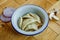 Boiled prepared homemade russian pelmeni, dumplings, ravioli with meat on grey plate with fresh parsley, pepper, wooden