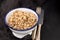 Boiled quinoa in white bowl on black background