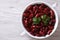 Boiled red kidney beans in a bowl closeup on wooden top view