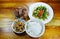 Boiled rice eat with fried anchovy and morning glory on table