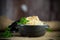 Boiled rice with vegetables and meat in a ceramic bowl on a wooden table