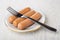 Boiled sausages, fork in plate on table