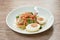 Boiled spicy salty egg half cut with dry shrimp and ginger salad on plate