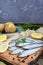 Boiled unpeeled potatoes in skins, a small salted fish of Baltic herring, sprats