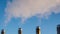 Boiler pipes with smoke against the blue sky, winter,