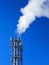 Boiler pipes with smoke on the blue sky background