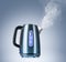 Boiling electric kettle gives off steam on blue background