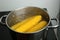 Boiling fresh corns in pot with hot water