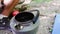 Boiling hot drink in nature, tea leaves in the water close-up.