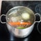Boiling meat broth in stockpot on ceramic cooker