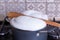 Boiling milk in a pan, wood spoon on the top