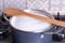 Boiling milk in a pan, wood spoon on the top