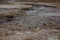 Boiling mudpots in the geothermal area Hverir and cracked ground around, Iceland in summer. Myvatn region, North part of Iceland