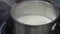 Boiling soy milk with thin yuba or tofu film in a steel pot. Hot fresh milk and gypsum