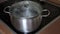 Boiling water in pan with a closed lid on a induction glass ceramic modern stove cook top