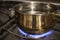 Boiling water in a steel casserole pot in a stove