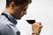 Bokal of red wine on white background, male sommelier appreciating drink
