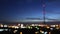 Bokeh background of dusky sky with tower silhouette and blinking city lights