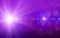 Bokeh background with purple glitter sparkles rays lights bokeh on purple background.